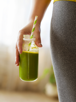 Woman drinking vegetable smoothie after fitness running workout