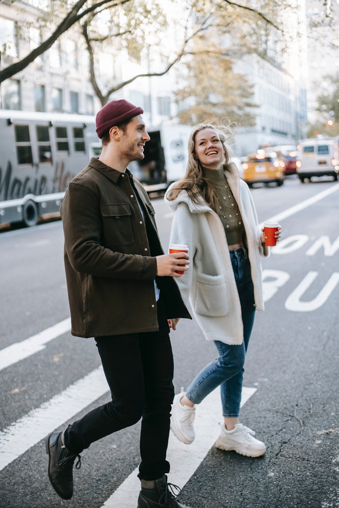 A woman and a man chatting with coffees on the street, nurturing a relationship