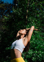 Woman in atheltic wear stretching in the sun