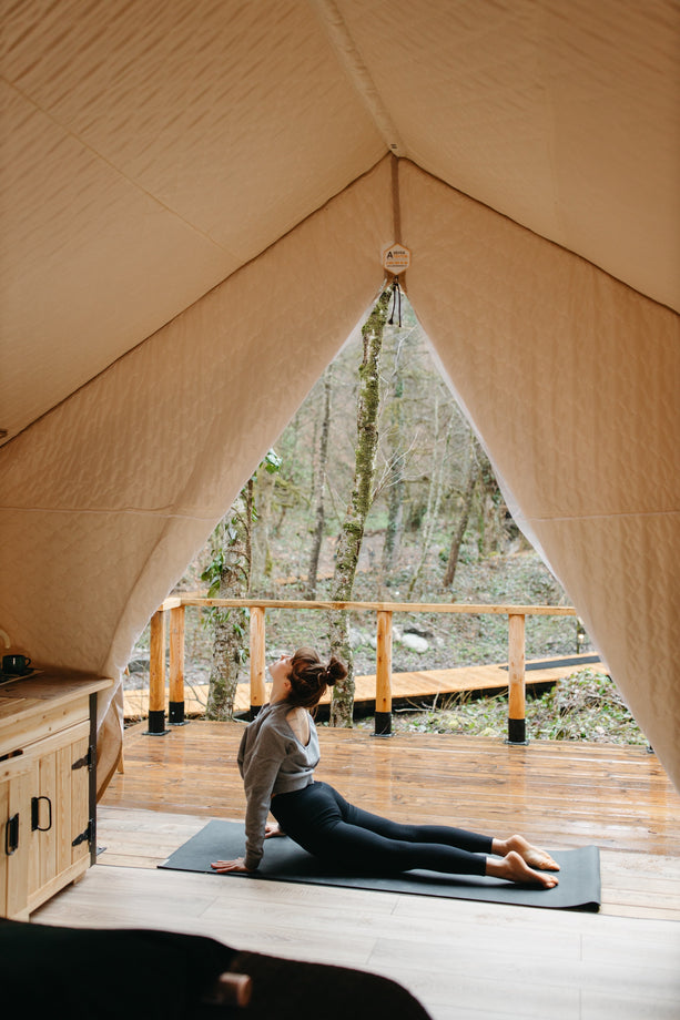 Woman practicing yoga on camp site