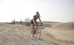Athletic woman biking on dirt path