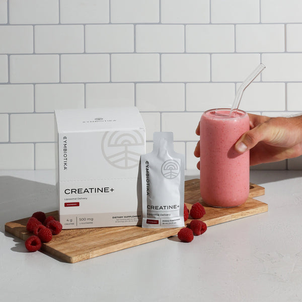 Cymbiotika Creatine+ sitting next to a Creatine+ Raspberry Smoothie